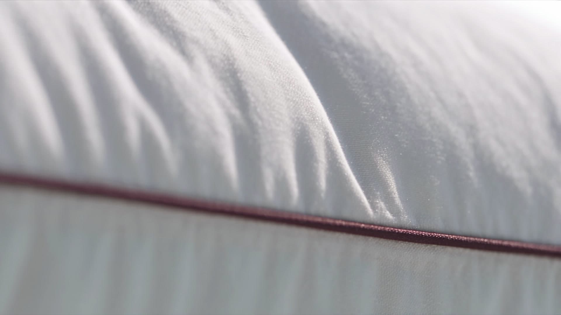 Close-up of the soft white fabric above the burgundy piping